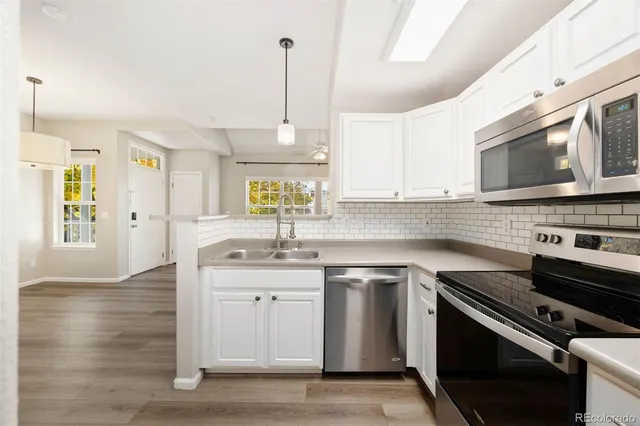 a kitchen with stainless steel appliances granite countertop a sink a stove a microwave a sink a refrigerator and cabinets