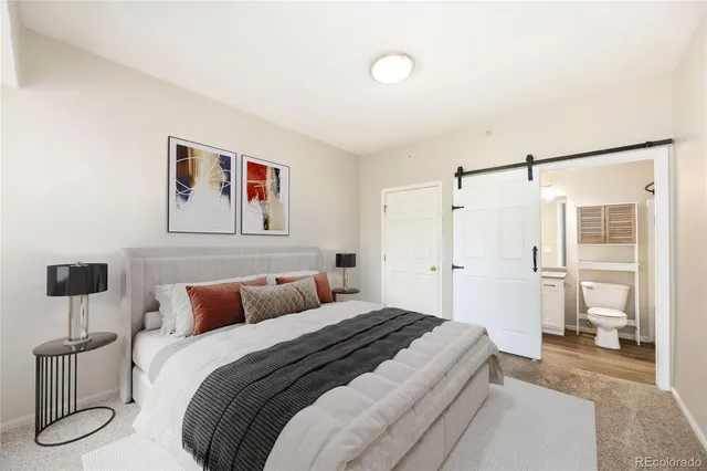 a bedroom with a bed and a painting on the wall