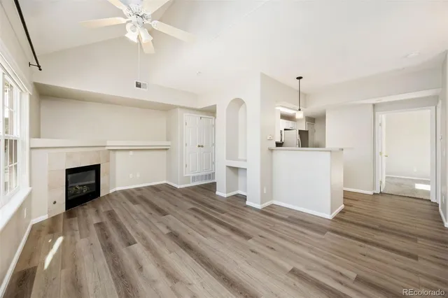 a view of empty room with wooden floor and fireplace