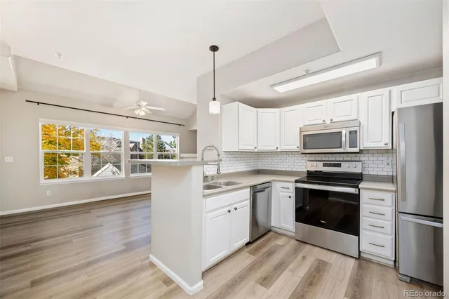a kitchen with stainless steel appliances granite countertop a refrigerator a stove a sink dishwasher a microwave oven with cabinets and wooden floor