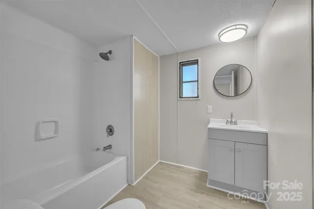 a bathroom with a granite countertop sink a toilet and bathtub