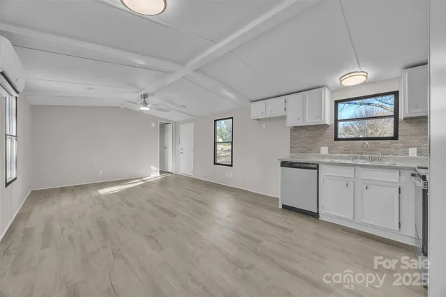 a view of a kitchen with a sink dishwasher microwave oven and cabinets