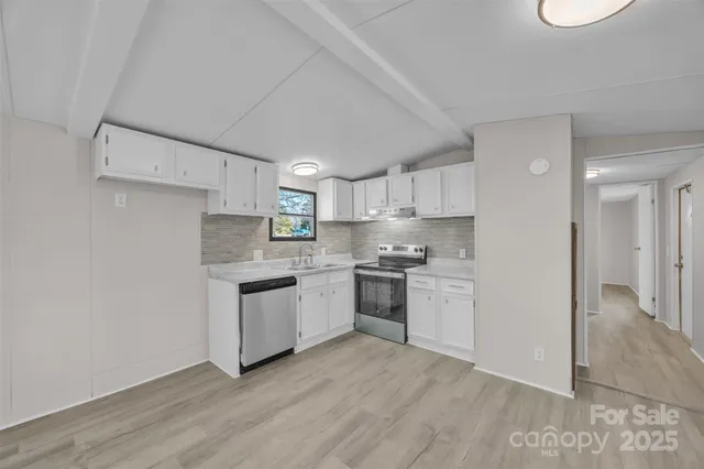 a kitchen with a refrigerator stove top oven and sink