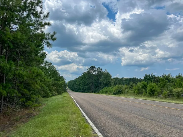 a view of a street with a yard in the background