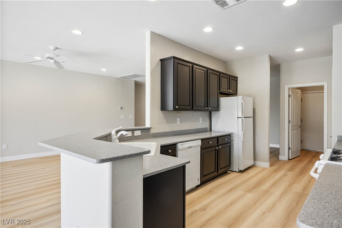 2563 Sargon Street Henderson, NV 89044 - Photo 11 of 35 Kitchen featuring a ceiling fan, light wood-style flooring, white appliances, recessed lighting, and a peninsula