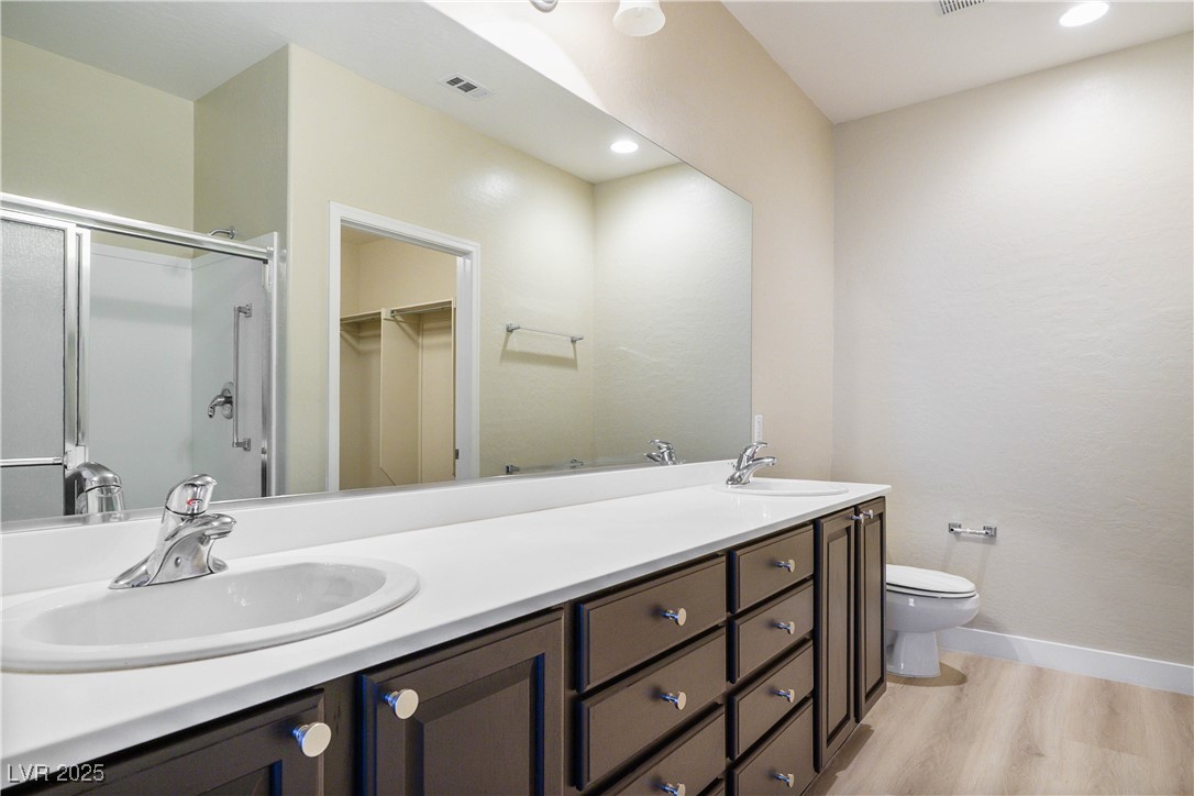 2563 Sargon Street Henderson, NV 89044 - Photo 17 of 35 Full bath featuring double vanity, wood finished floors, a shower stall, a spacious closet, and recessed lighting