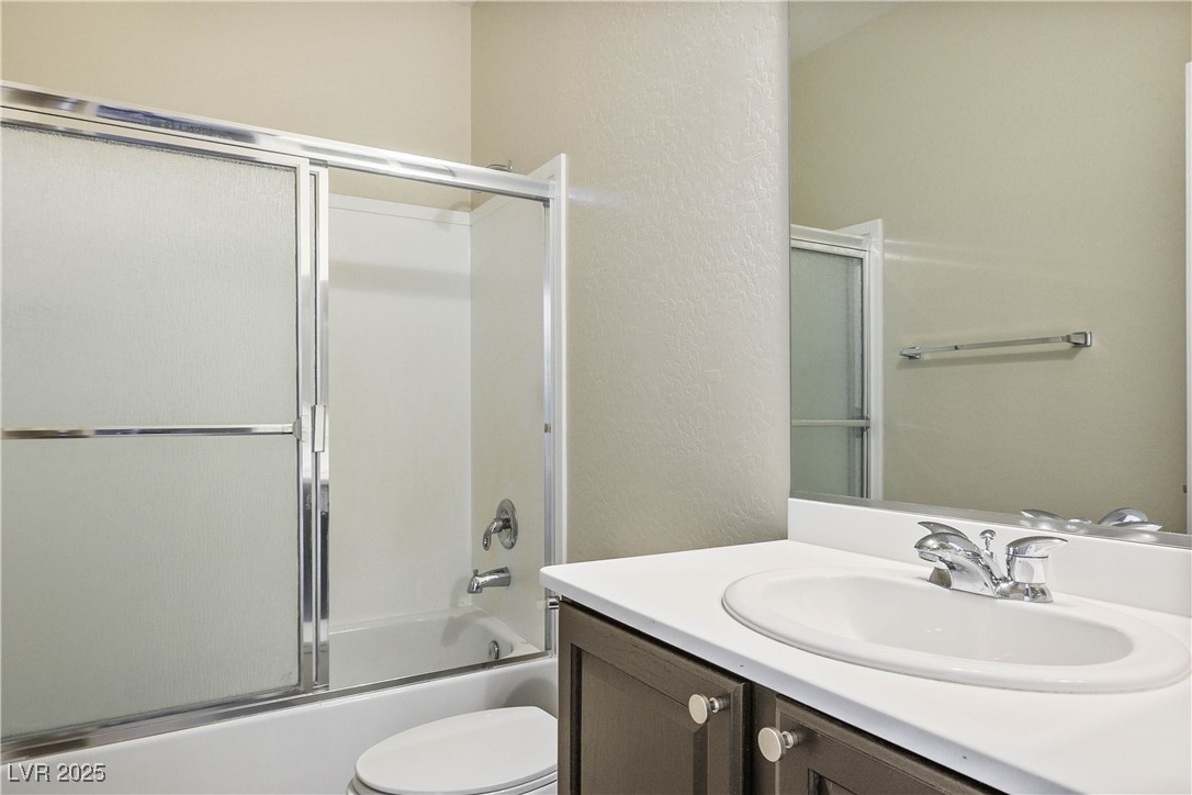 2563 Sargon Street Henderson, NV 89044 - Photo 19 of 35 Bathroom with vanity, enclosed tub / shower combo, and a textured wall