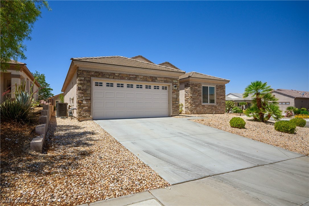 2563 Sargon Street Henderson, NV 89044 - Photo 2 of 35 Single story home with concrete driveway, stone siding, a garage, and a tile roof