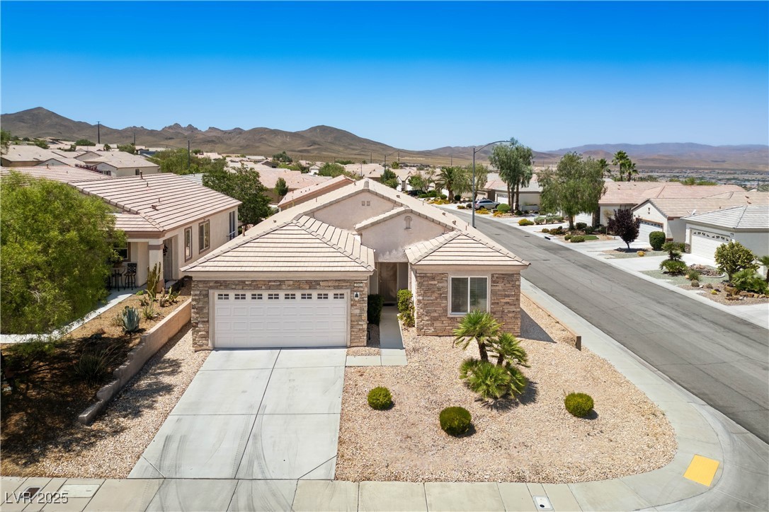 2563 Sargon Street Henderson, NV 89044 - Photo 25 of 35 Single story home with a garage, a mountain view, stone siding, and concrete driveway