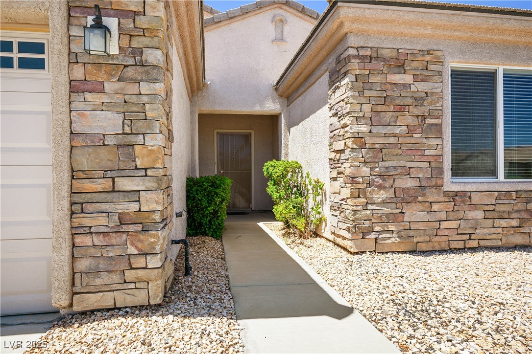 2563 Sargon Street Henderson, NV 89044 - Photo 4 of 35 Doorway to property featuring stone siding and stucco siding