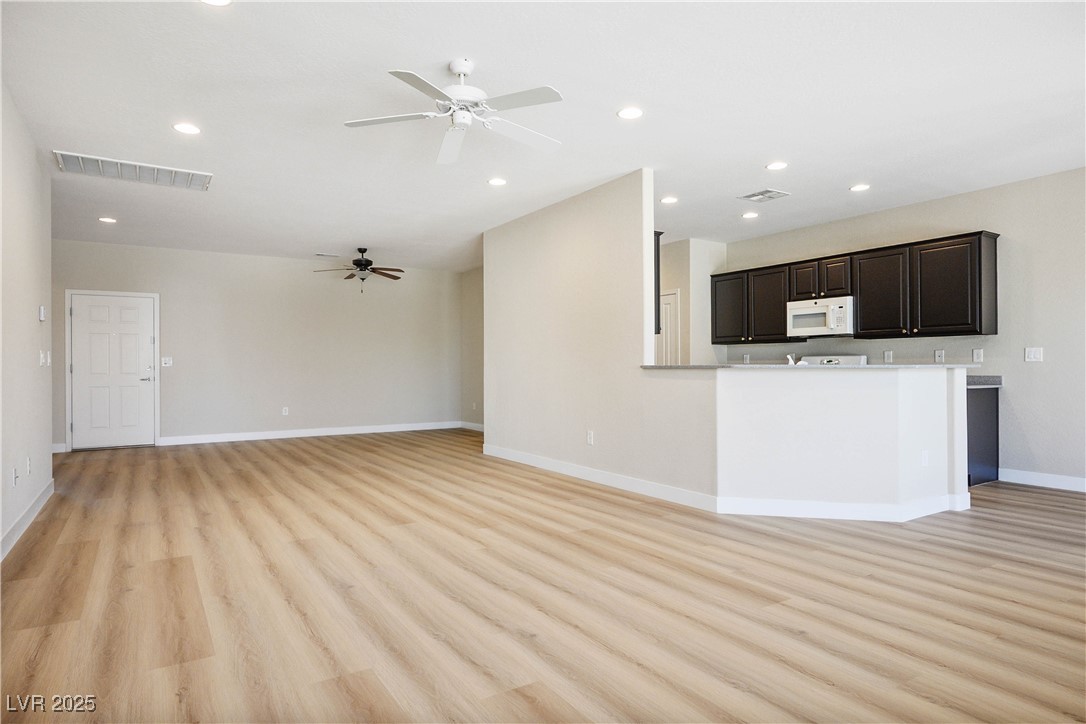 2563 Sargon Street Henderson, NV 89044 - Photo 8 of 35 Unfurnished living room with light wood finished floors, a ceiling fan, and recessed lighting