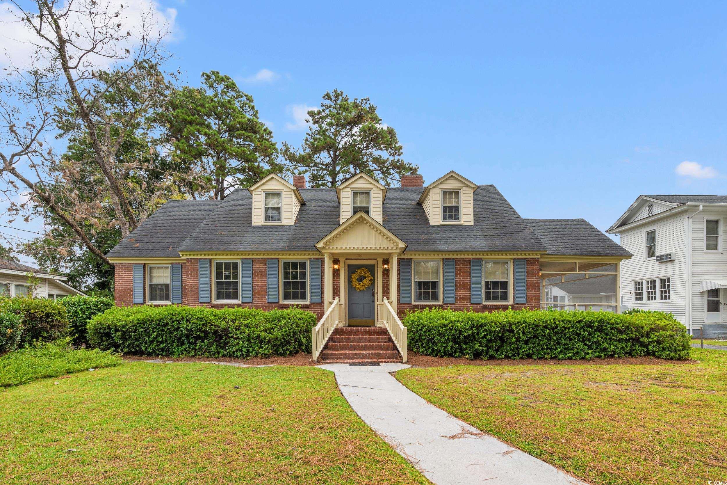 310 North Main Street Mullins, SC 29574 - Photo 11 of 35 New england style home featuring a front yard, brick siding, and a shingled roof