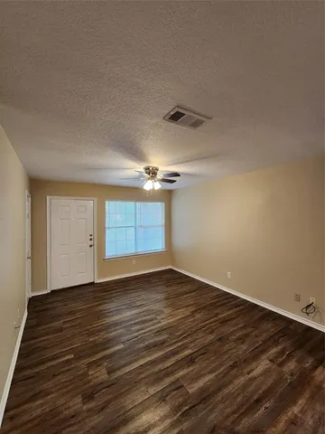a view of an empty room with wooden floor