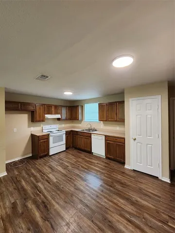 a large kitchen with a large counter top space stainless steel appliances and cabinets