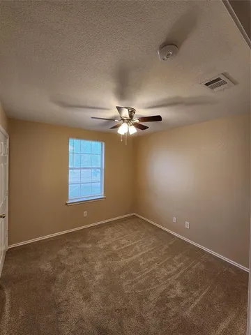 en empty room with windows and ceiling fan view