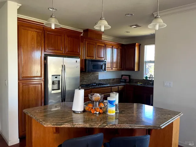 a kitchen with kitchen island granite countertop a sink window and refrigerator
