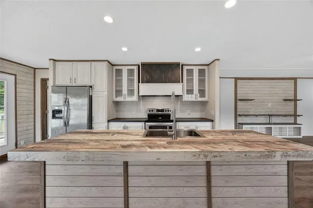 a kitchen with kitchen island granite countertop a sink stainless steel appliances and cabinets