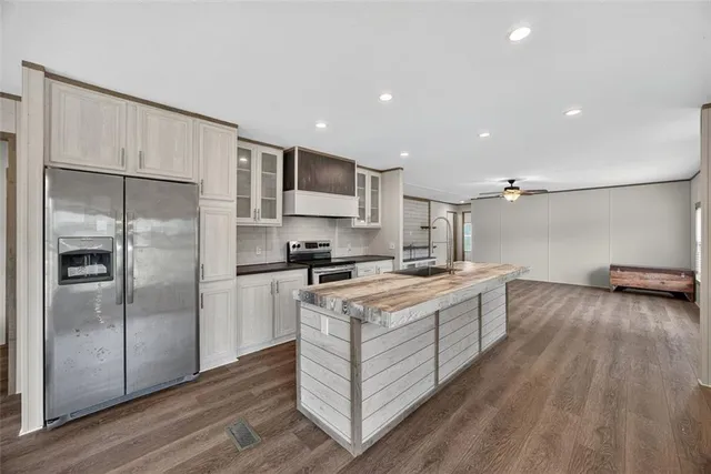 a kitchen with a refrigerator sink and cabinets