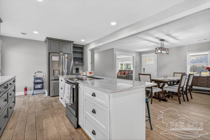 8940 Indian Ford Road Milton, FL 32570 - Photo 24 of 54 a kitchen with stainless steel appliances a dining table chairs stove refrigerator and cabinets