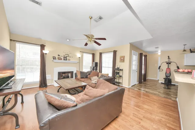 a living room with furniture a flat screen tv and a large window