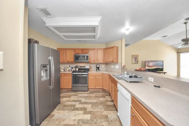 a kitchen with stainless steel appliances a refrigerator sink and cabinets