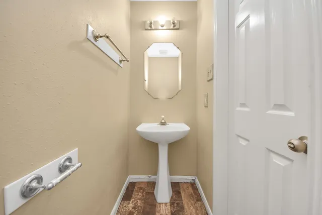 a bathroom with a sink a light fixture and a mirror