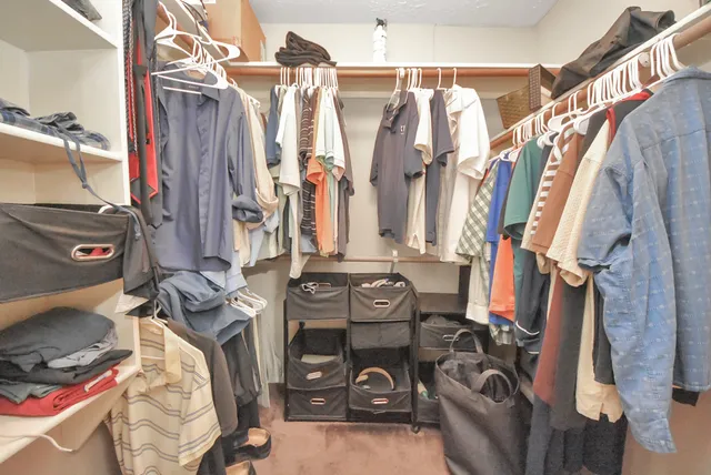 a view of walk in closet with clothes