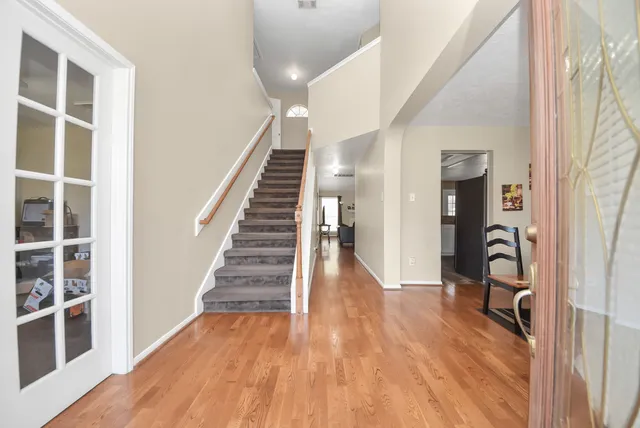 a view of a hallway with wooden floor and windows