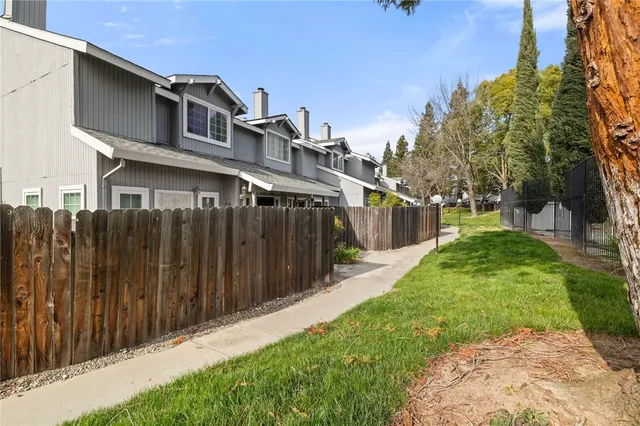 a front view of a house with a yard and trees