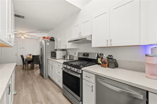 a kitchen with a white cabinets and appliances