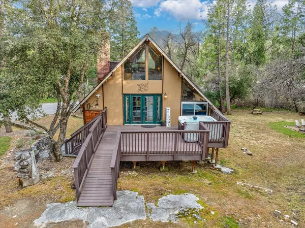 a view of a house with a wooden deck and furniture