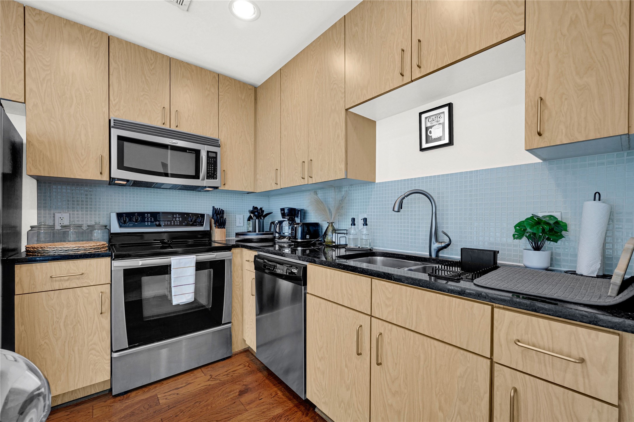 5925 Almeda Road, Unit 10806 Houston, TX 77004 - Photo 20 of 34 a kitchen with granite countertop cabinets stainless steel appliances and wooden floor