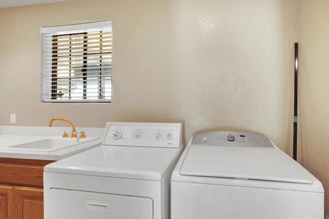 a backyard of a house with table and chairs under an umbrella