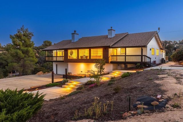 an aerial view of a house with a yard and lake view