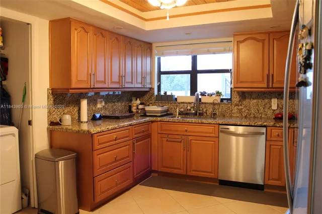 a kitchen with stainless steel appliances granite countertop a stove a sink and a refrigerator