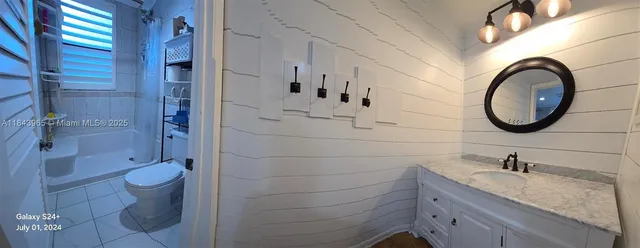 a bathroom with a granite countertop toilet a sink and a mirror