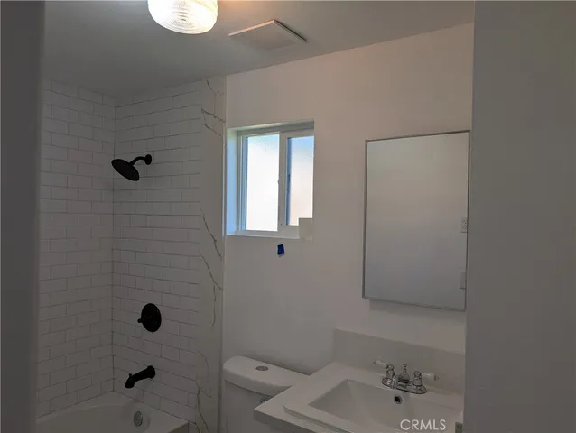 a bathroom with a shower a toilet and a bathtub