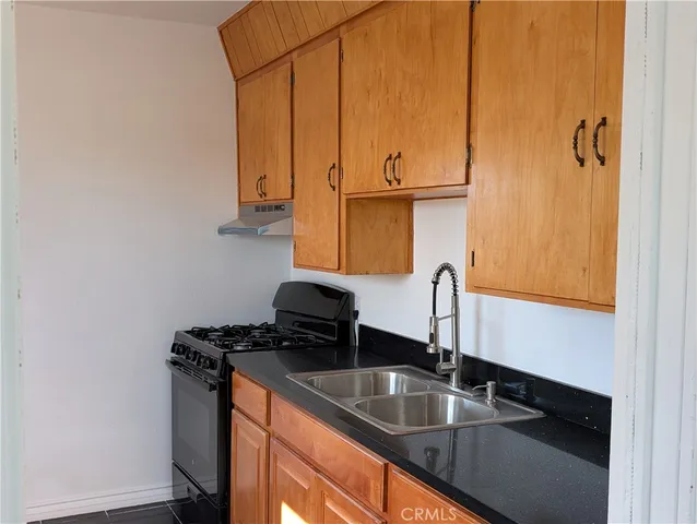 a kitchen with stainless steel appliances granite countertop a sink stove and microwave