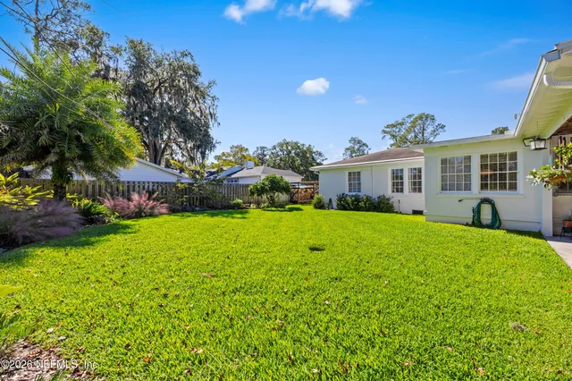 a view of a house with backyard and sitting area