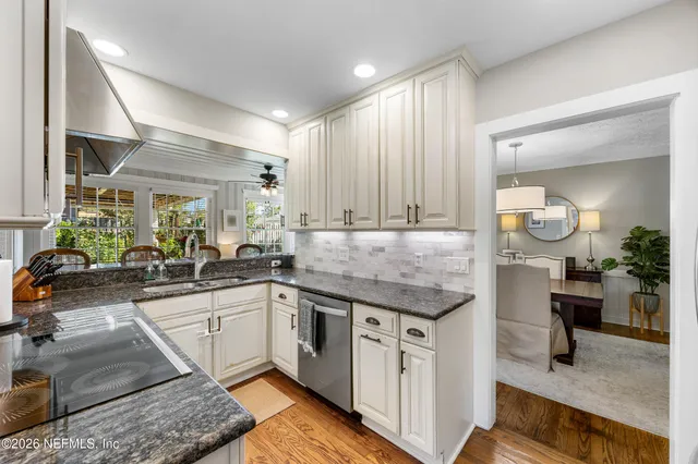 a kitchen with granite countertop a sink and cabinets