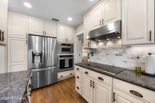 a kitchen with granite countertop a refrigerator and a sink