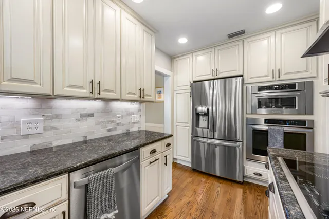 a kitchen with granite countertop a refrigerator sink and microwave