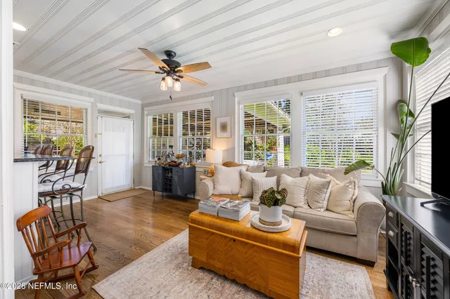 a living room with furniture a flat screen tv and a large window