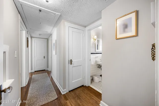 a view of a hallway with wooden floor and closet area