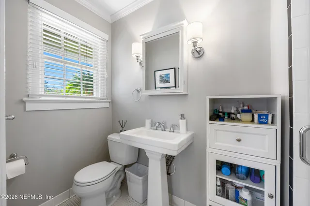 a bathroom with a sink toilet and a window