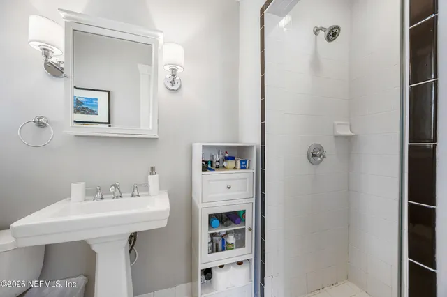 a bathroom with a sink a toilet and shower