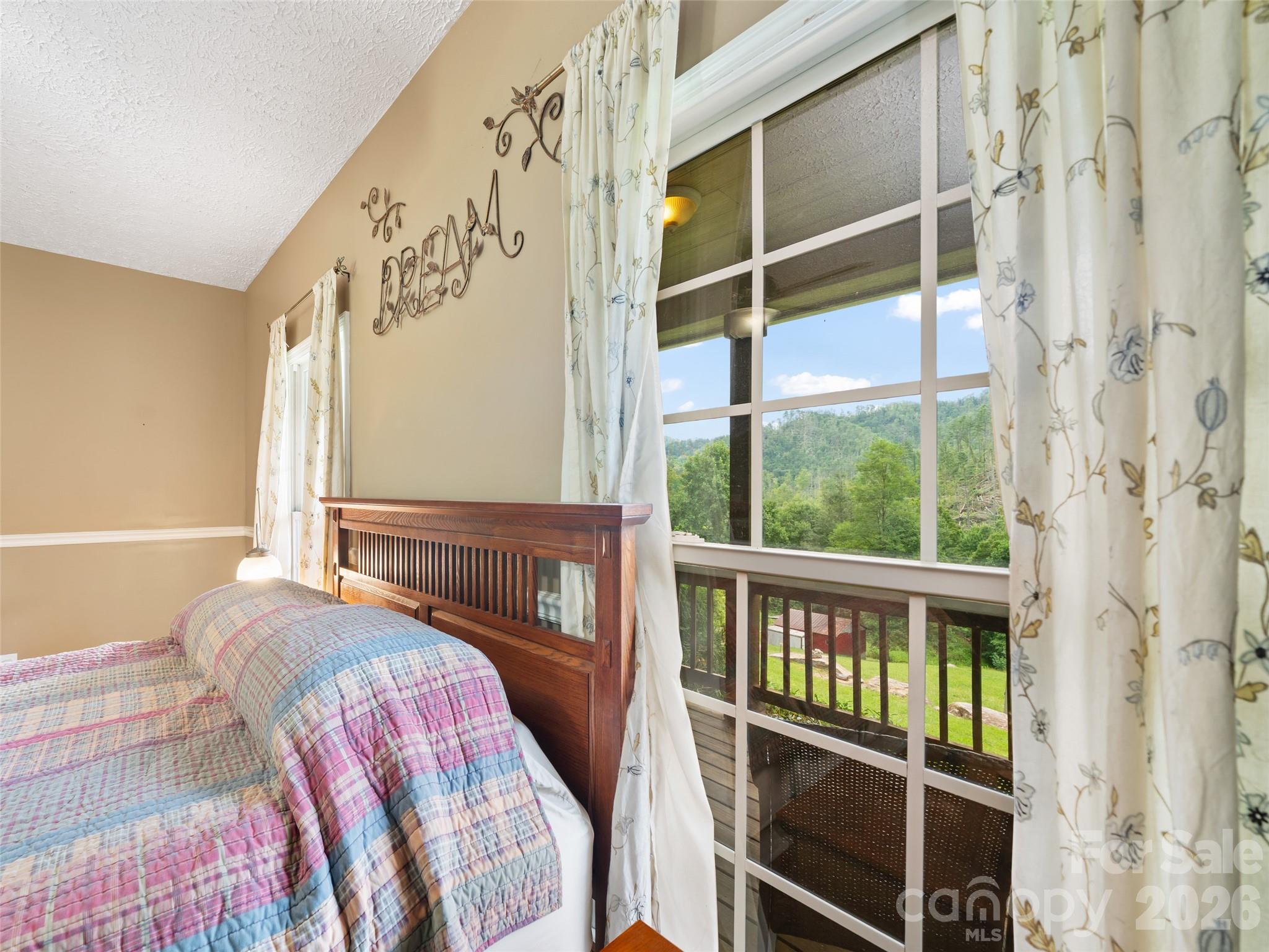 2216 Beans Creek Road Bakersville, NC 28705 - Photo 15 of 39 a bedroom with a bed and a window
