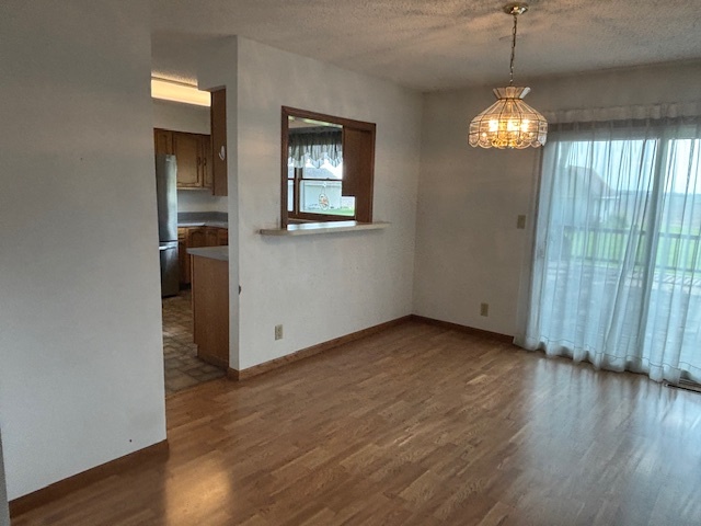 5287 South Mill Pond Road Rochelle, IL 61068 - Photo 18 of 50 an empty room with wooden floor chandelier and windows