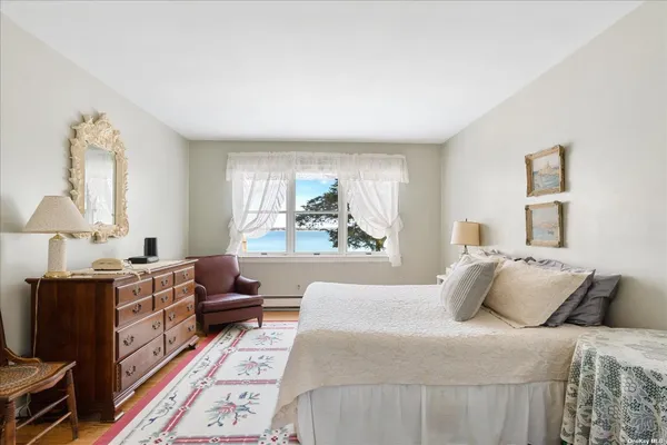 a bedroom with a bed wooden floor and window