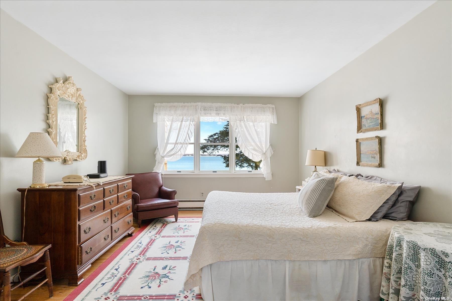 1155 Old Harbor Road New Suffolk, NY 11956 - Photo 14 of 21 a bedroom with a bed wooden floor and window